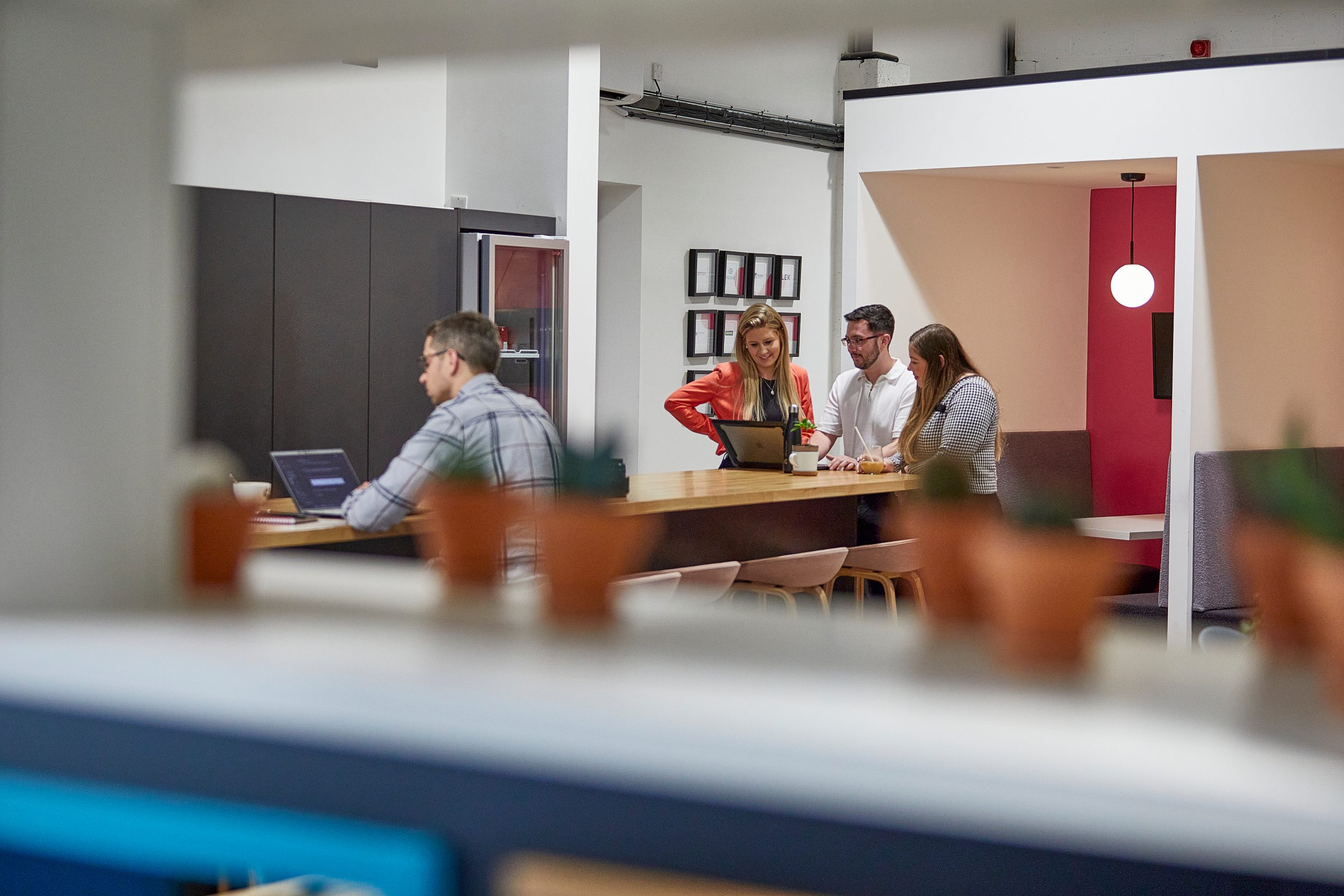 Colleagues collaborating around a standing desk in a modern office